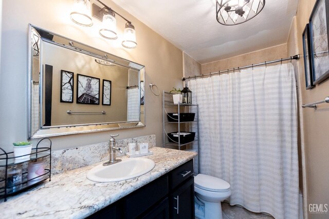 bathroom featuring walk in shower, vanity, and toilet