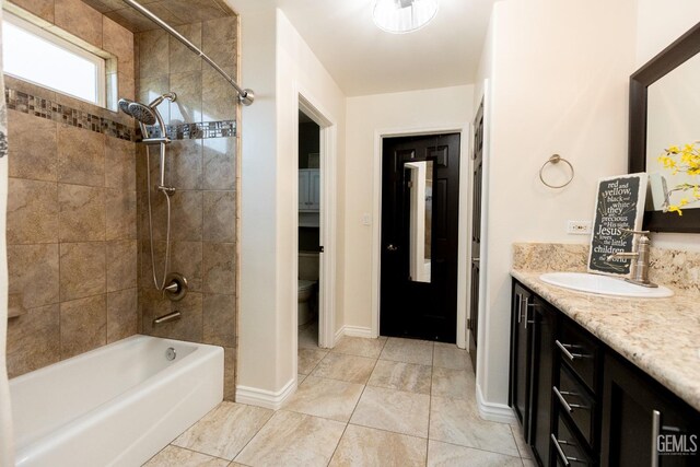 full bathroom with vanity, tile patterned flooring, tiled shower / bath, and toilet