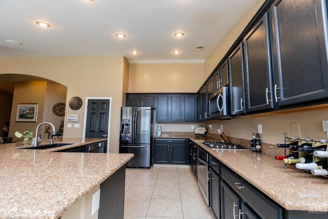 kitchen featuring light stone countertops, sink, light tile patterned floors, and stainless steel appliances