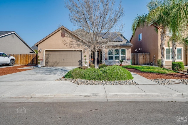 view of front of house featuring an attached garage, solar panels, fence, driveway, and stucco siding