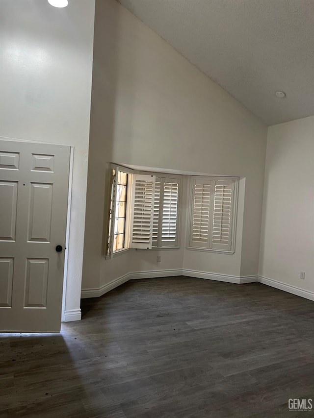 entryway with dark hardwood / wood-style flooring and high vaulted ceiling