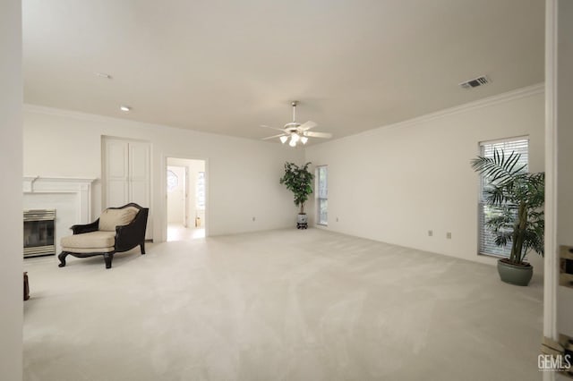 sitting room with ornamental molding, a healthy amount of sunlight, and light colored carpet