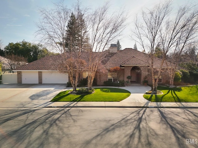 mediterranean / spanish home featuring a garage and a front lawn