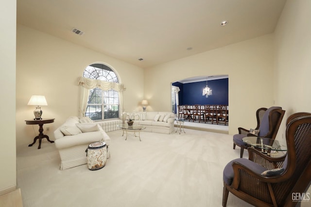 living room with light colored carpet and a notable chandelier