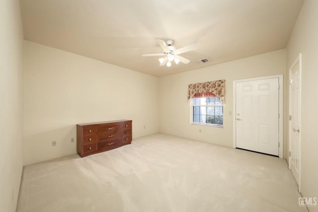 spare room featuring light colored carpet and ceiling fan