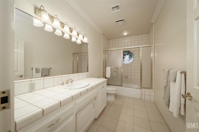 full bathroom featuring shower / bath combination with glass door, vanity, toilet, crown molding, and tile patterned floors