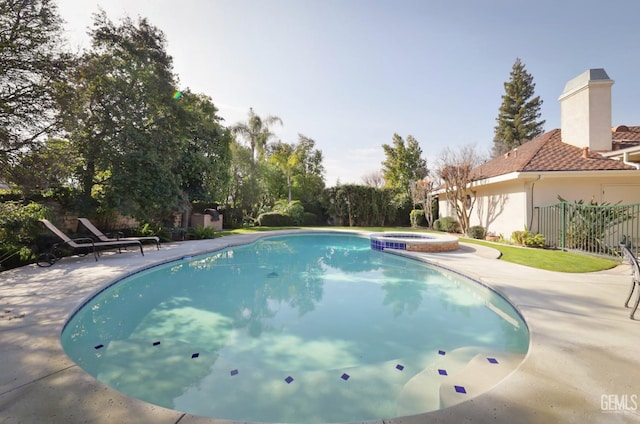 view of swimming pool featuring an in ground hot tub and a patio area