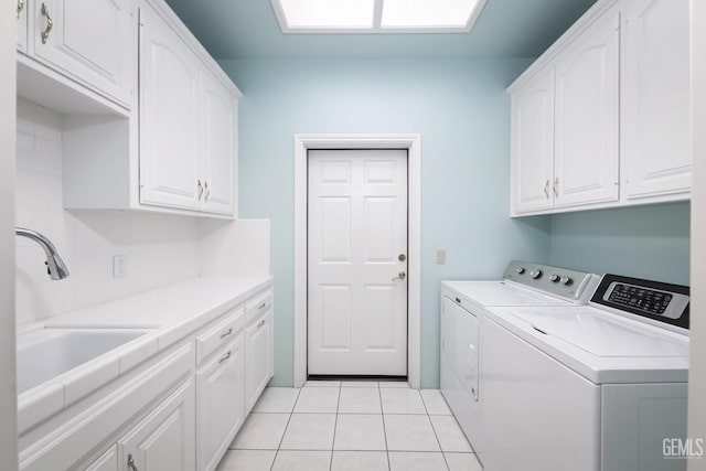 laundry area with cabinets, sink, light tile patterned floors, and independent washer and dryer