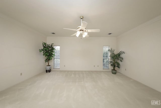 carpeted empty room featuring crown molding, plenty of natural light, and ceiling fan