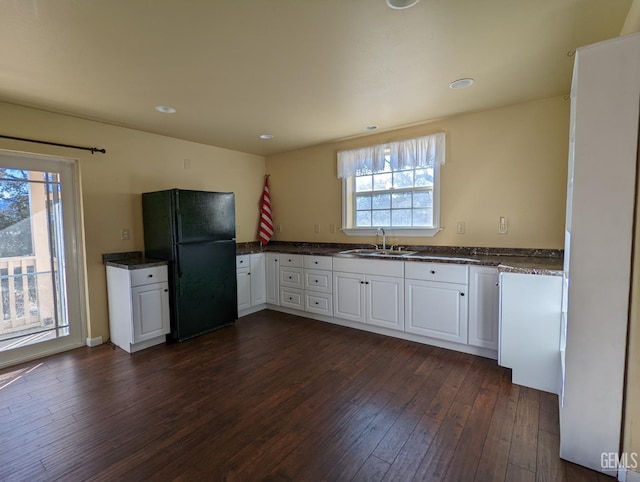 29201 Angus Ct, Tehachapi, CA 93561 - kitchen featuring freestanding refrigerator, dark wood-style floors, white cabinets, recessed lighting, and dark stone counters