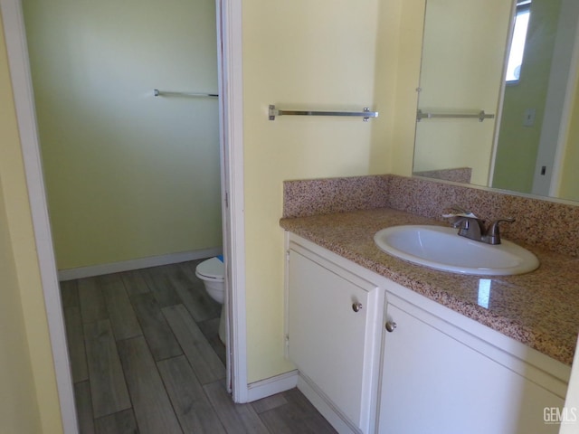3001 Peach Tree Ct, Bakersfield, CA 93301 - bathroom with baseboards, wood finished floors, toilet, and vanity