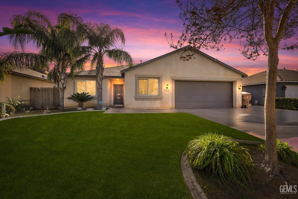 ranch-style home featuring a yard and a garage