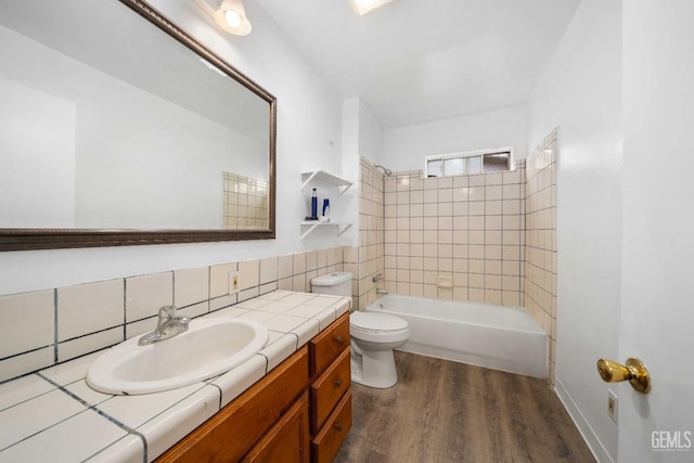 full bathroom featuring vanity, tiled shower / bath, toilet, tasteful backsplash, and wood-type flooring