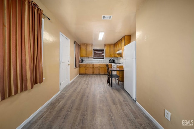 kitchen featuring decorative backsplash, sink, white fridge, and wood-type flooring