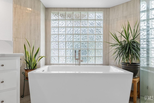 bathroom featuring a tub and tile walls