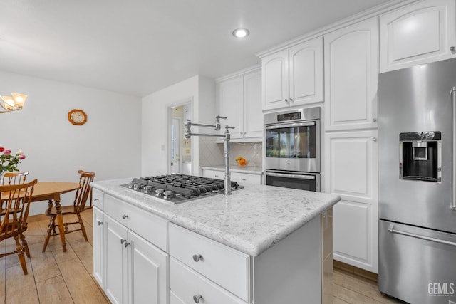 kitchen with white cabinets, appliances with stainless steel finishes, and a center island