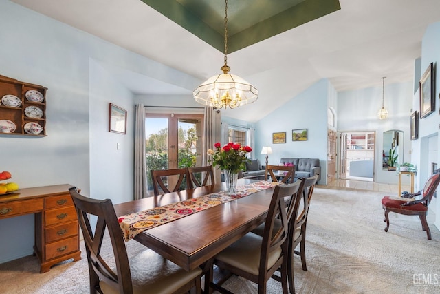 carpeted dining room featuring french doors, lofted ceiling, and a notable chandelier