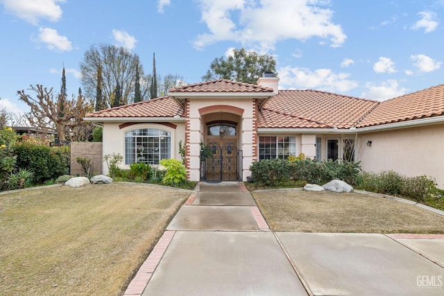 mediterranean / spanish home featuring a front lawn