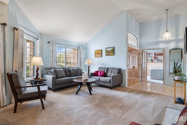 carpeted living room with high vaulted ceiling