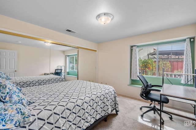 bedroom featuring light carpet and a closet