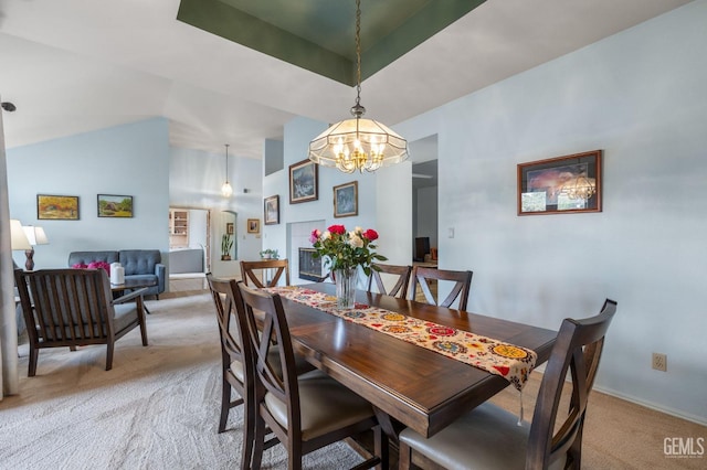 carpeted dining room featuring vaulted ceiling and a notable chandelier