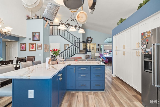 3809 Wensley Ct, Bakersfield, CA 93311 - kitchen with stainless steel fridge, blue cabinetry, open floor plan, white cabinetry, and light wood-type flooring