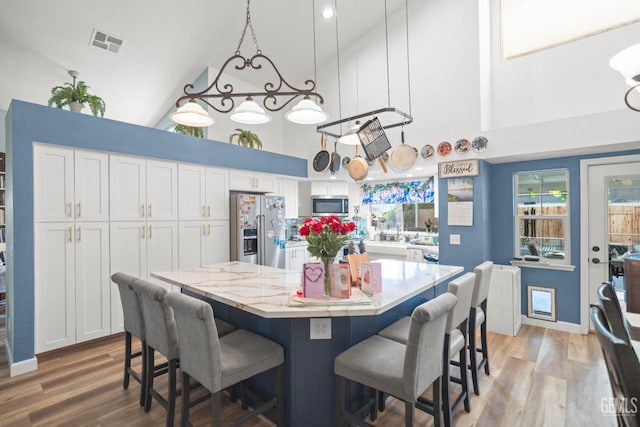 3809 Wensley Ct, Bakersfield, CA 93311 - dining area featuring a towering ceiling, light wood-type flooring, and a chandelier