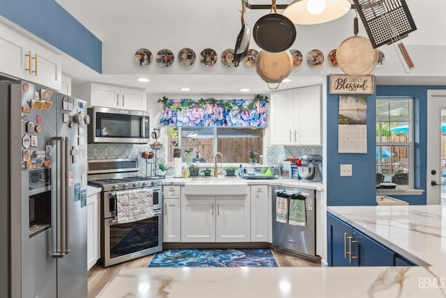 3809 Wensley Ct, Bakersfield, CA 93311 - kitchen with appliances with stainless steel finishes, white cabinetry, tasteful backsplash, and light stone counters