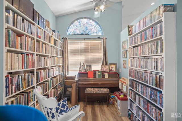3809 Wensley Ct, Bakersfield, CA 93311 - sitting room with wall of books, wood finished floors, a ceiling fan, and high vaulted ceiling