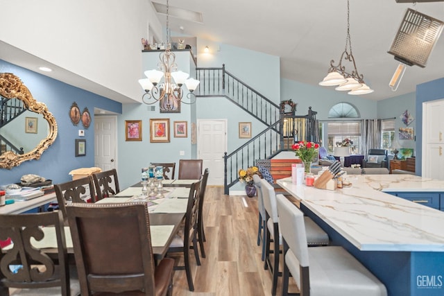 3809 Wensley Ct, Bakersfield, CA 93311 - dining area featuring light wood finished floors, stairs, a chandelier, and a towering ceiling