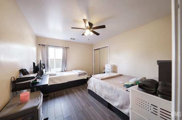 bedroom featuring dark wood-type flooring, ceiling fan, and a closet