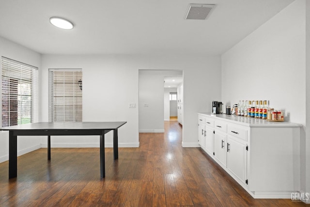 interior space with dark hardwood / wood-style flooring and white cabinets