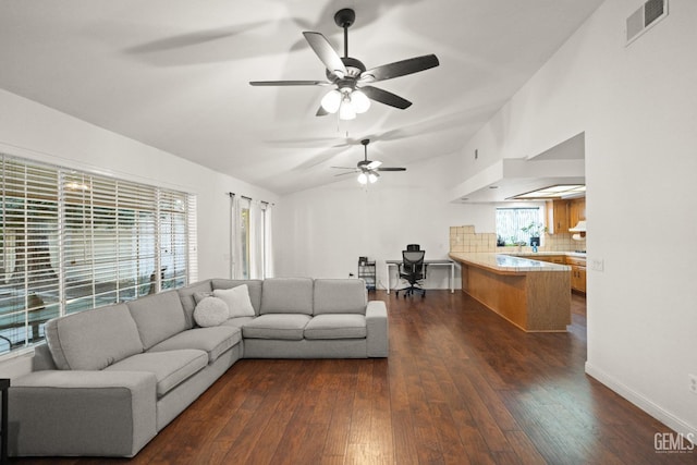 living room featuring dark hardwood / wood-style floors, vaulted ceiling, and a wealth of natural light