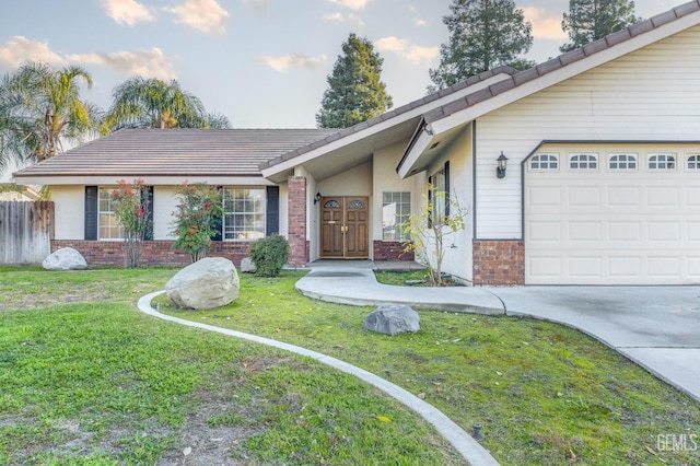 ranch-style house with a garage and a lawn