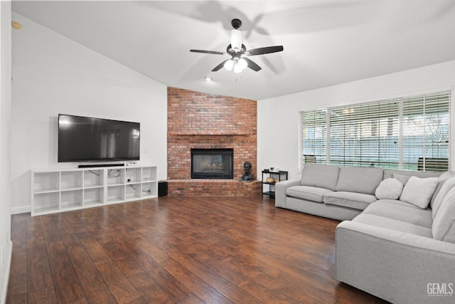 living room featuring ceiling fan, lofted ceiling, dark hardwood / wood-style flooring, and a fireplace