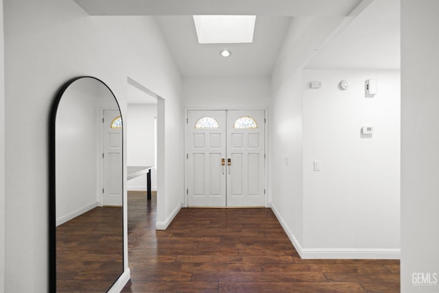 foyer entrance featuring dark wood-type flooring and a skylight