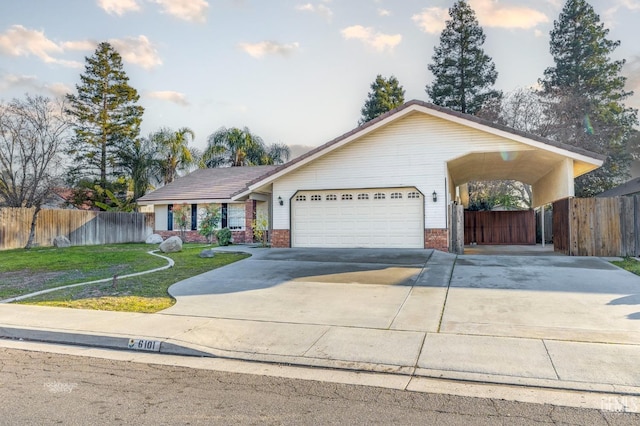 single story home featuring a garage, a carport, and a front lawn