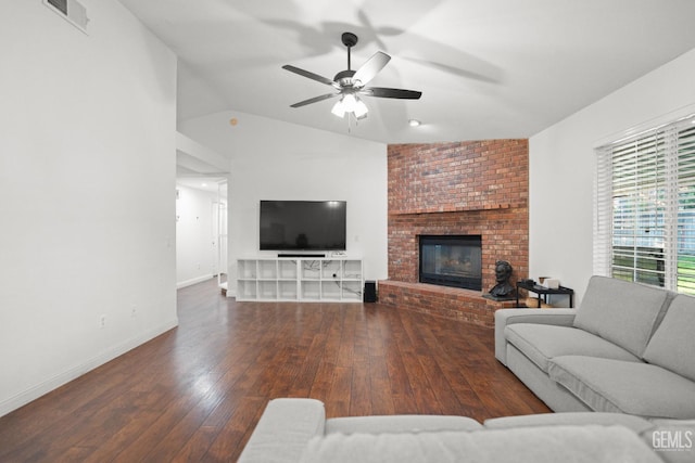 living room featuring ceiling fan, dark hardwood / wood-style floors, vaulted ceiling, and a brick fireplace