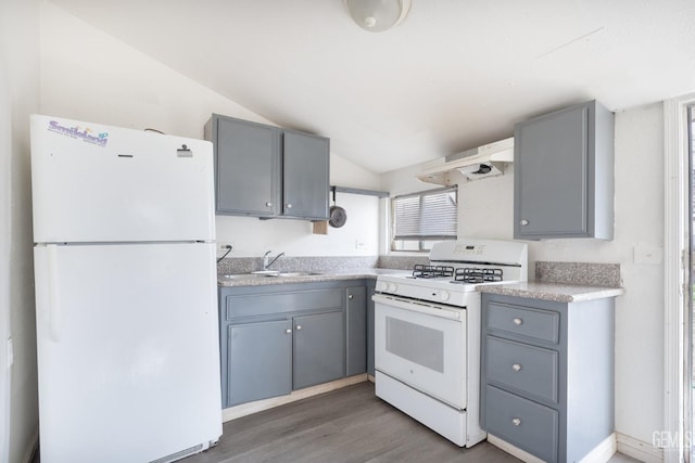 kitchen featuring gray cabinetry, sink, range hood, lofted ceiling, and white appliances