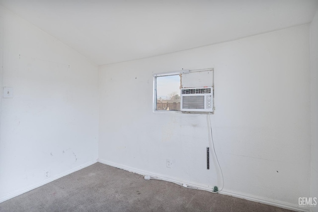 carpeted spare room featuring cooling unit and lofted ceiling