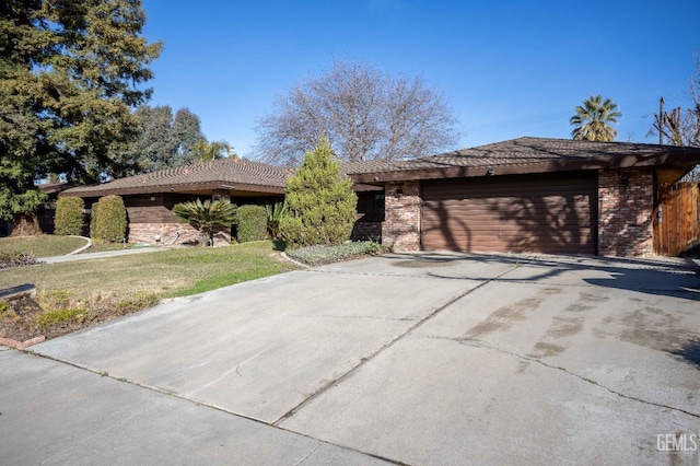 ranch-style house with a garage and a front yard