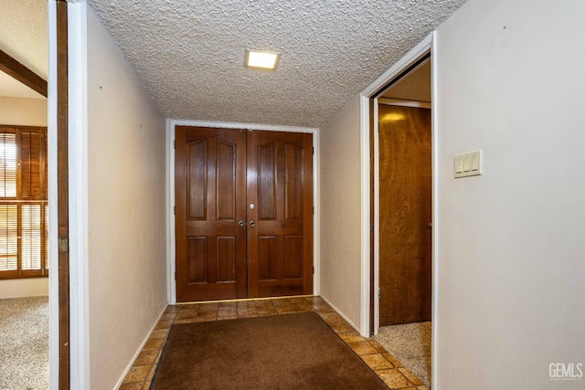 hall featuring light colored carpet and a textured ceiling