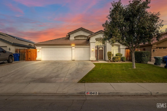 view of front of home with a yard and a garage