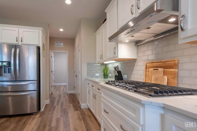 13620 Stonethwaite Ln, Bakersfield, CA 93311 - kitchen with appliances with stainless steel finishes, under cabinet range hood, white cabinetry, light countertops, and tasteful backsplash