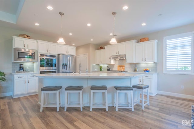 13620 Stonethwaite Ln, Bakersfield, CA 93311 - kitchen with appliances with stainless steel finishes, under cabinet range hood, backsplash, light countertops, and white cabinets