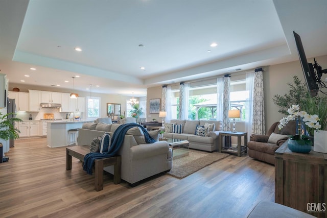 13620 Stonethwaite Ln, Bakersfield, CA 93311 - living room featuring a tray ceiling, light wood finished floors, and recessed lighting