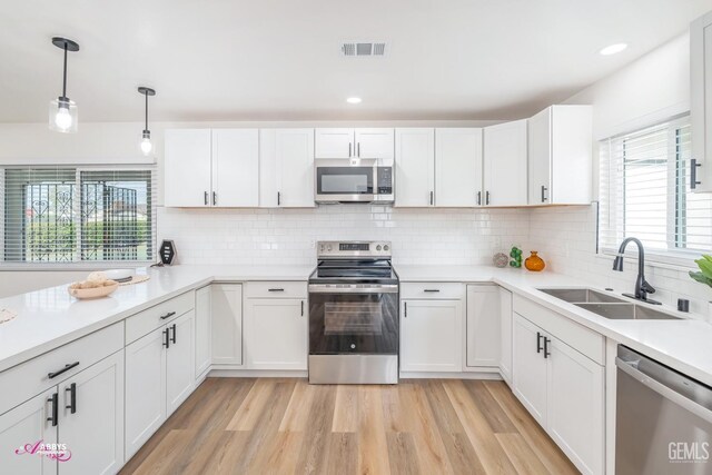 kitchen featuring white cabinets, appliances with stainless steel finishes, and sink