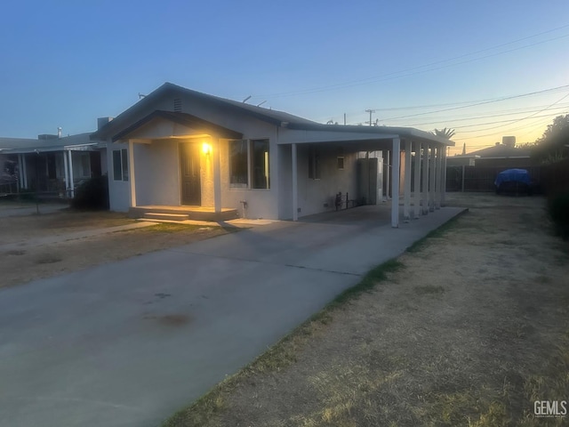 1225 Austin St, Delano, CA 93215 - rear view of property with concrete driveway, stucco siding, and a carport