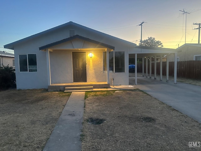 1225 Austin St, Delano, CA 93215 - view of front facade featuring concrete driveway, an attached carport, and stucco siding