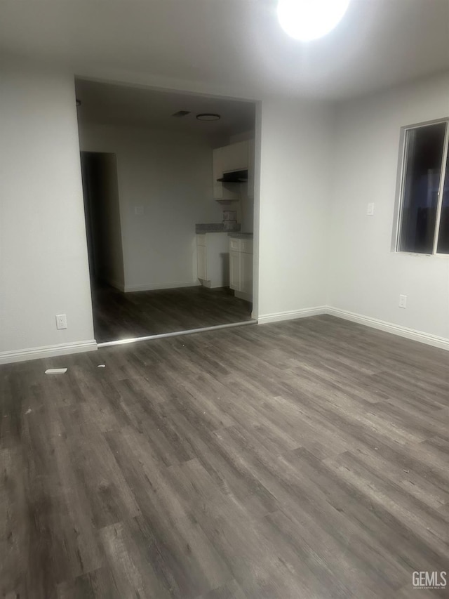1225 Austin St, Delano, CA 93215 - unfurnished living room with dark wood-style floors and baseboards